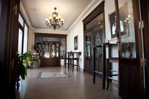 a hallway with a dining room and a chandelier at Hotel El Capricho in Villanueva del Trabuco