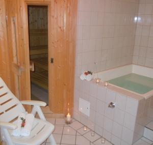 a bathroom with a tub and a chair and lights at Hotel Lugerhof in Weiding +46 photos