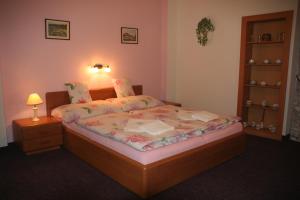a bedroom with a bed and a night stand with a lamp at Chebsky dvur - Egerlander Hof in Karlovy Vary