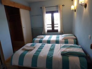 
a bed room with a white bedspread and a blue comforter at Le Relais de l'Artuby in Séranon
