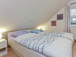 a white bed in a room with a window at Apartment in Nieheim on the edge of the forest in Sandebeck