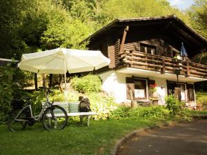 SchöneckenにあるWell-kept apartment, located in a wooded areaの傘を持つ家の前に駐輪場