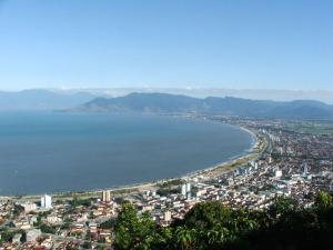 uma vista aérea de uma cidade e do oceano em Suíte Aconchegante em Caraguatatuba