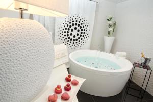 a white bath tub sitting next to a white toilet at Aux 5 Sens in Tillé