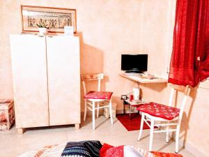um quarto com um frigorífico e uma secretária com cadeiras em B&B Peschi in Fiore em Valeggio sul Mincio