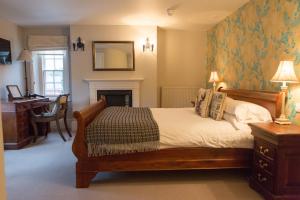 sypialnia z łóżkiem, biurkiem i lustrem w obiekcie The King's Head w mieście Winchester