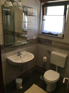 La salle de bains est pourvue de toilettes, d'un lavabo et d'une fenêtre. dans l'établissement Apartment Konavec, à Kobarid