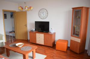 een woonkamer met een tv op een dressoir en een tafel bij Apartmán Leny in Tatranská Lomnica