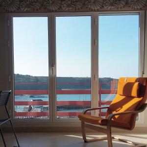 una silla sentada frente a una ventana en Apartamento Bellavista, en Luarca