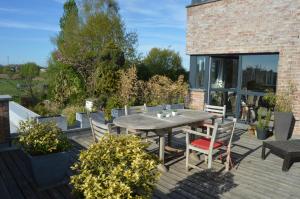 eine Terrasse mit einem Tisch und Stühlen auf einer Terrasse in der Unterkunft Apartment Nathalie in Comines