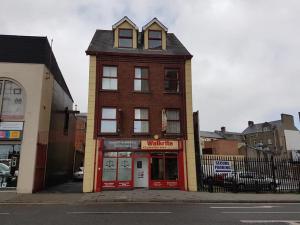 um edifício de tijolos vermelhos na esquina de uma rua em Grant Rooms em Derry Londonderry