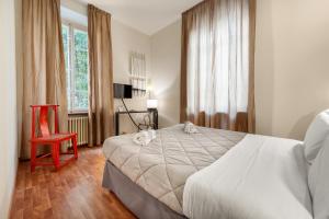 - une chambre avec un grand lit et une chaise rouge dans l'établissement Lucca in Villa Lucrezia, à Lucques