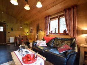 sala de estar con sofá de cuero y mesa en Majestic Chalet in Arville with Bubble Bath, en Smuid