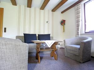 ein Wohnzimmer mit einer Couch und einem Tisch und Stühlen in der Unterkunft Apartment in Oberkirchen near Winterberg Skiing in Schmallenberg