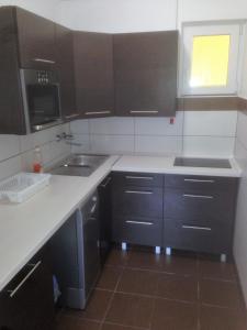 a kitchen with black cabinets and a sink at Laura-haus in Vonyarcvashegy