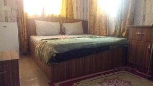 a bedroom with a bed with a wooden frame at Adinkra City Hotel in Kasoa