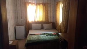a small bedroom with a bed and a window at Adinkra City Hotel in Kasoa
