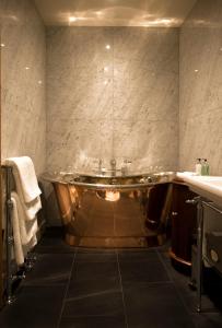 a bathroom with a tub in the middle of the room at Mingary Castle - Restaurant with Rooms in Kilchoan