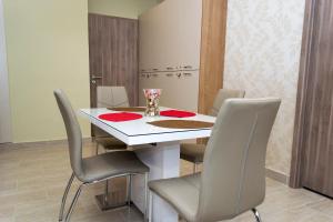 a dining room with a white table and chairs at Ditta Rooms Debrecen in Debrecen