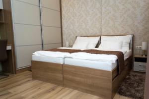 1 dormitorio con 1 cama grande con almohadas blancas en Ditta Panzio, en Debrecen