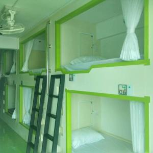 two bunk beds in a room with a ladder at The Port Hostel in Surat Thani