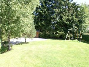 a park with a swing set in the grass at Attractive Holiday Home in Xhoffraix with Barbecue in Longfaye