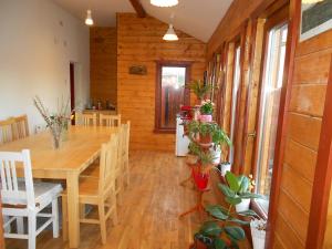 a dining room with a table and some potted plants at Eszter Guesthouse in Sîncrăieni