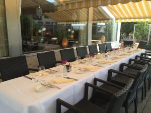 un lungo tavolo in un ristorante con tavoli e sedie di Hôtel de Chailly a Montreux