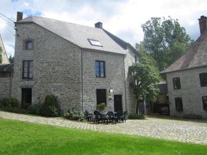 ein altes Steinhaus mit einem Tisch und Stühlen in der Unterkunft Lively Holiday Home in Viroinvlal with Garden in Treignes