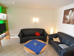 a living room with two leather couches and a table at Holiday home in Olsdorf in Bettingen