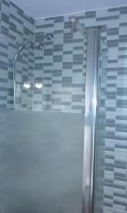 a shower in a bathroom with blue and white tiles at Hotel la Masia in Portbou +71 photos