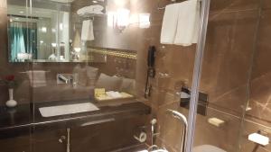 a bathroom with a shower and a sink and a mirror at Peninsula Redpine-Airport in Mumbai