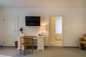 a room with a desk and a tv on the wall at Hotel Schewe in Löhne