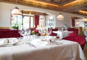 Un comedor con una mesa con copas de vino. en Hotel Kronsbühel, en Tirolo