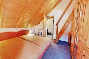 a bedroom with a bed and a wooden ceiling at Landhaus Will in Hilders +8 photos