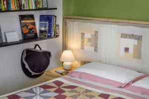 1 dormitorio con cama, lámpara y libros en Casa Bosio, en Bosio