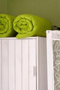 1 cama con almohadas verdes en la parte superior de un estante blanco en Casa Bosio, en Bosio