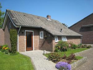 een stenen huis met een deur en een tuin bij Tranquil Holiday Home in Margraten in Margraten