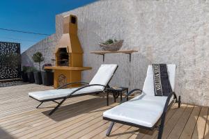 twee stoelen op een houten terras met open haard bij Lux Apartment in Jadranovo