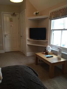 a bedroom with a bed and a table and a television at The Swan Hotel Bar and Grill in Maldon