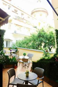 un patio avec des tables et des chaises et un bâtiment dans l'établissement Chiaia Suites, à Naples