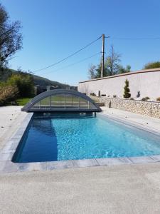 una piscina con un puente de cristal sobre ella en Domaine Le Puits du Moulin, en Comberjon