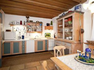 a large kitchen with wooden cabinets and a table at Cosy holiday home with gazebo in Weißenburg in Bayern