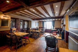 a restaurant with tables and chairs in a room at The Longboat Inn in Penzance