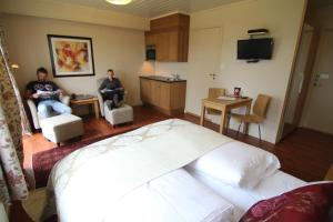 deux hommes assis sur des chaises dans une chambre d'hôtel dans l'établissement Solund Leileghetshotell, à Hardbakke