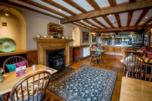 a living room with a fireplace and a table and chairs at The Longboat Inn in Penzance +38 photos