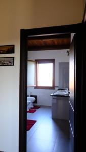 La salle de bains est pourvue d'un lavabo, de toilettes et d'une fenêtre. dans l'établissement La Baia Casa Vacanze, à Portoscuso