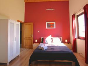 a bedroom with a red wall with a bed in it at Classy Holiday Home in Martilly with bubble bath in Martilly