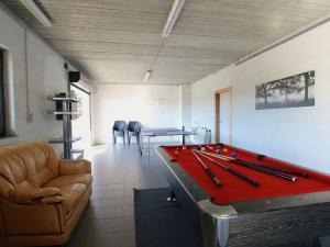 a living room with a red pool table and chairs at Classy Holiday Home in Martilly with bubble bath in Martilly