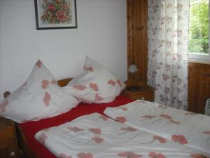 Cama con sábanas y almohadas rojas y blancas en North Sea Holiday Home in Horumersiel with Terrace, Barbecue en Bremke